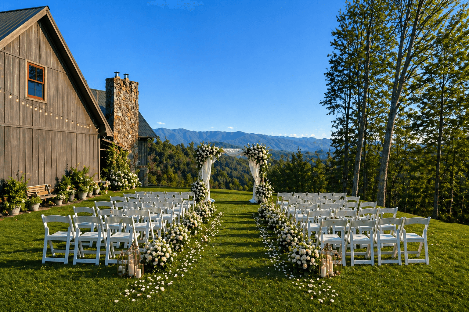 A beautifully arranged outdoor wedding venue with white chairs and floral decorations, set against a mountain backdrop.