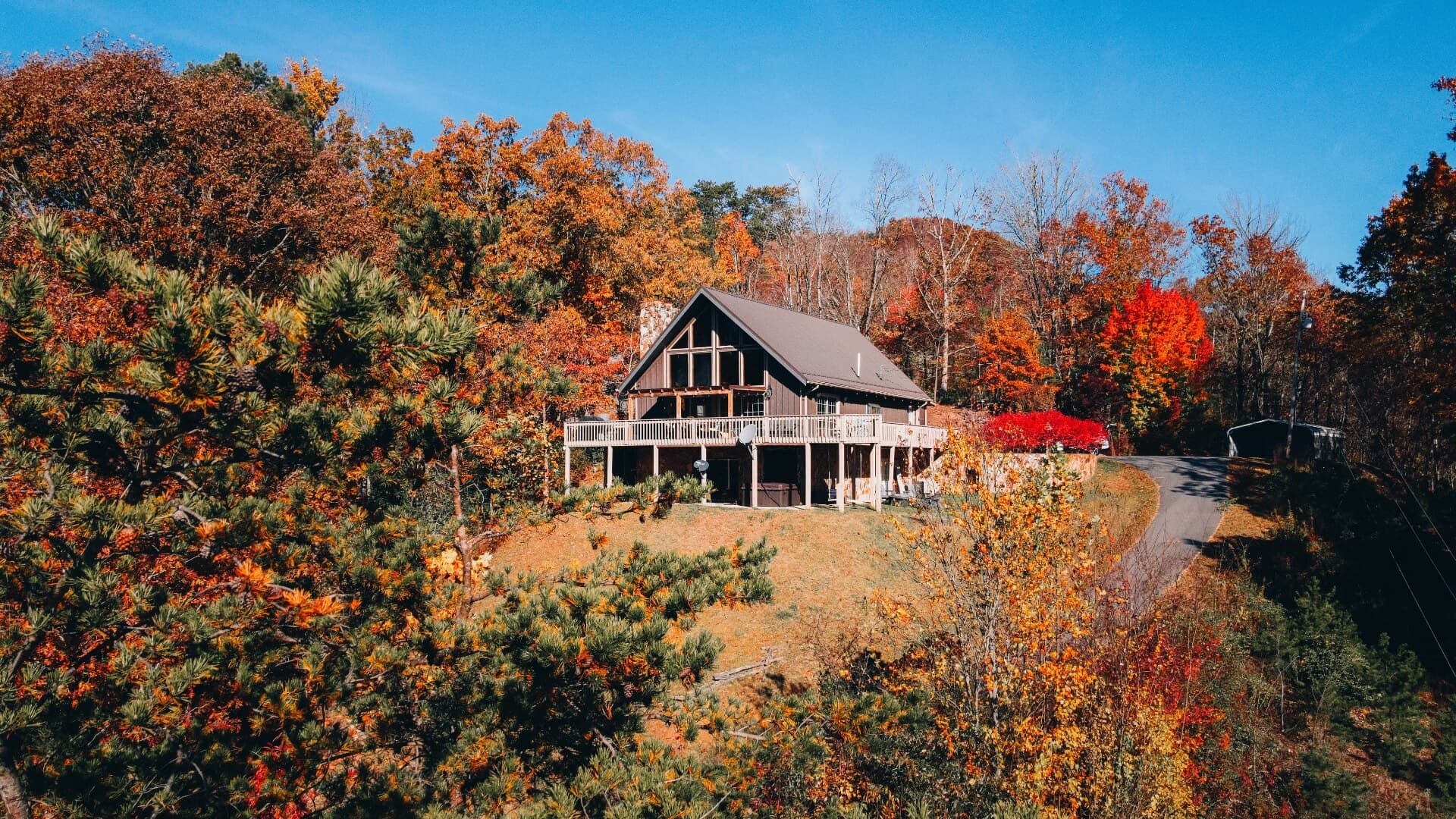 A rustic home surrounded by vibrant autumn foliage.